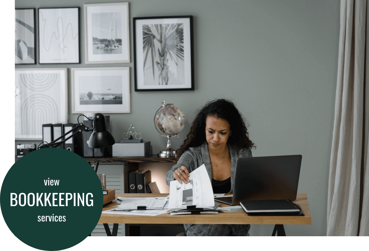 A women is sitting at an office desk completing her bookkeeping